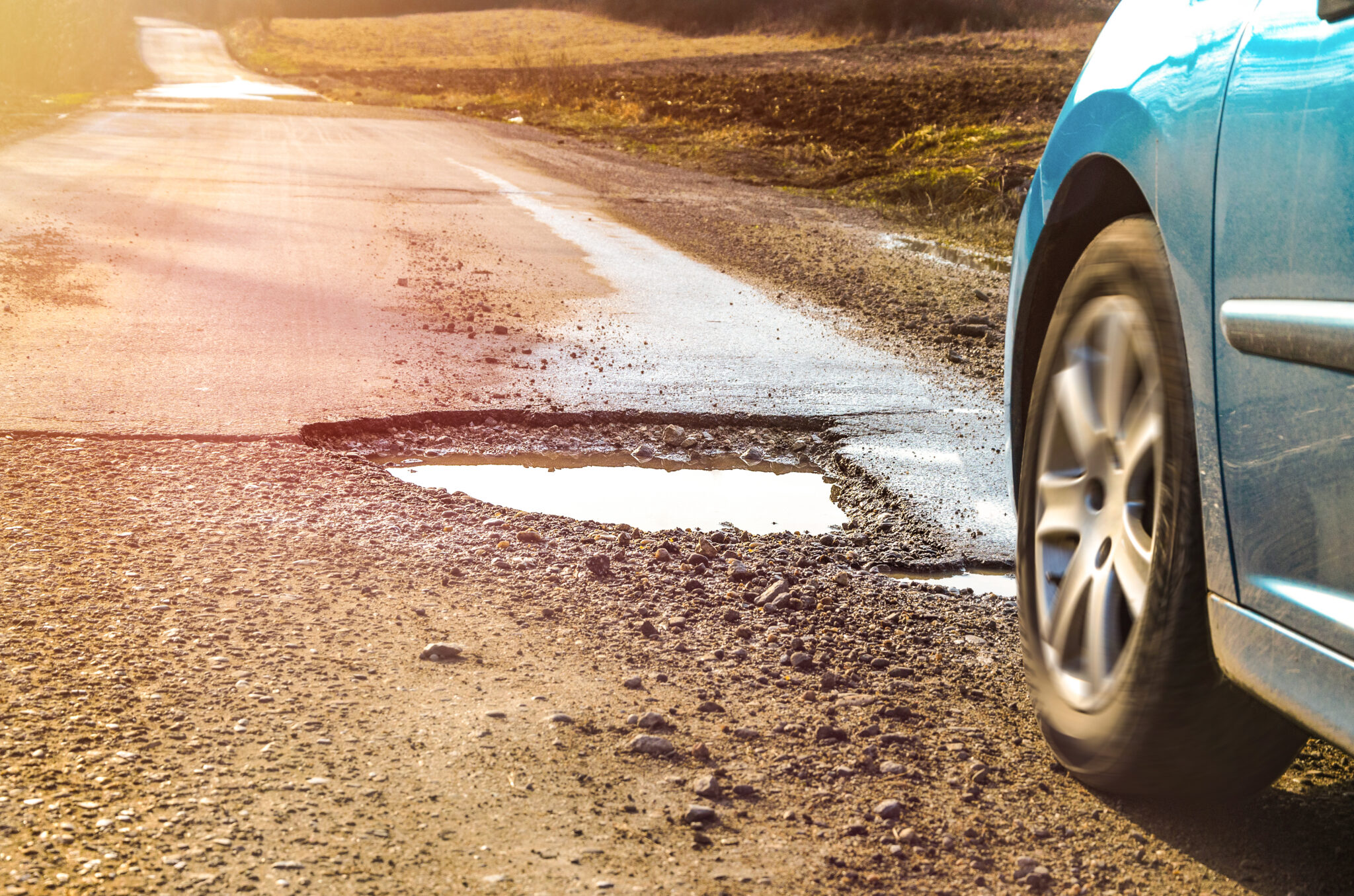 car driving into pothole